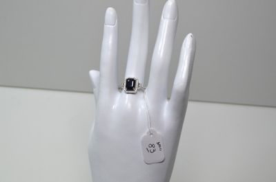 une main de mannequin blanche avec une bague au doigt