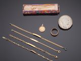 an assortment of jewellery including a coin, bracelets, and a necklace