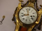 a gold clock on the wall with a clock face on it
