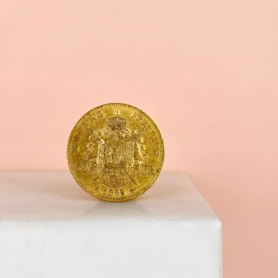 a gold coin sitting on top of a white pedestal