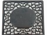 a black metal square with a circular design on it