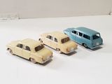 three toy cars sitting next to each other on a white surface
