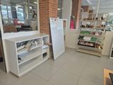 a white refrigerator and shelves in a store with a woman in the background