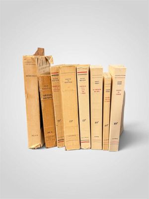 plusieurs livres sont empilés sur une surface blanche