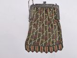 an old beaded purse hanging on a wall