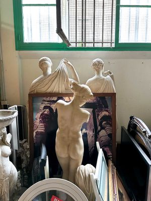 a statue of a woman standing next to a clock in a room