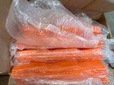 many bags of carrots in a box on the floor
