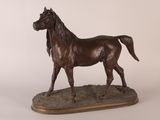 statue d'un cheval debout sur un socle en bois, sur fond blanc