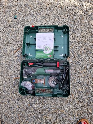 une boîte verte contenant des outils, posée par terre