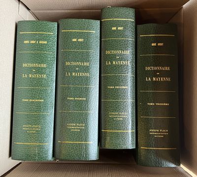 trois livres verts dans une boîte en carton posée sur une table