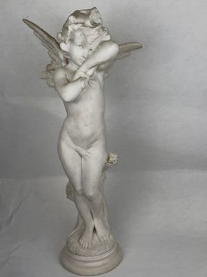 statue d'un ange chérubin tenant un oiseau, posée sur un socle