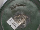 a close up of a green pot with a tag on it