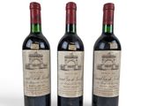 three bottles of wine are lined up on a white surface