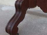 a wooden table with a glass top on a cement floor