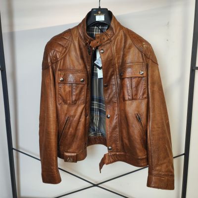 une veste en cuir marron suspendue à un portant dans un magasin de vêtements