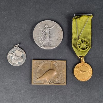 three medals and a medal on a table with a green ribbon