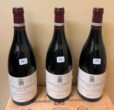 three bottles of wine sit on top of a wooden box