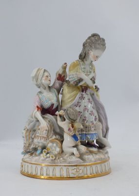 une figurine représentant une femme et un enfant jouant avec un chien