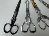 five pairs of scissors sitting next to each other on a table
