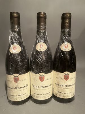 three bottles of wine wrapped in plastic sitting on a table