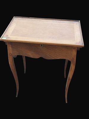 une petite table en bois avec un plateau en verre, sur fond noir