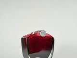 a red glass vase with a silver base on a white surface