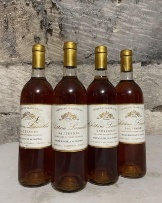 quatre bouteilles de vin sont alignées sur une table