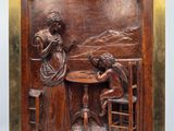 une image représentant une plaque en bois sur laquelle figurent une femme et un homme en train de jouer aux cartes