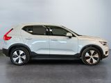 a white volvo suv parked in a showroom with a grey background