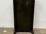 a small black table with a black top on a concrete floor