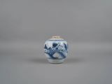 un petit vase bleu et blanc orné d'un singe