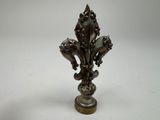 an antique bronze fleur - de - lis on a marble base