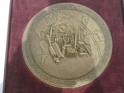 une médaille d'or sur laquelle est représenté un train