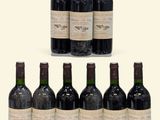 several bottles of wine are lined up on a white surface