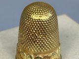 a gold thimble sitting on top of a marble block