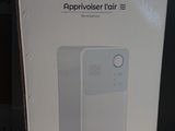 packaging of a white air purifier sitting on top of a wooden table