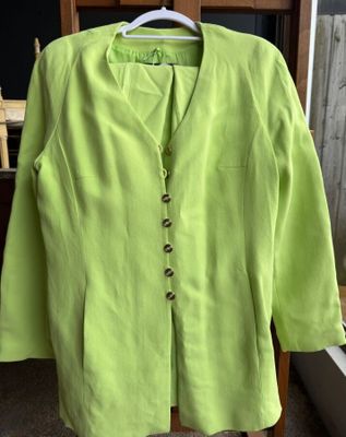 une veste vert citron suspendue à un cintre devant une fenêtre