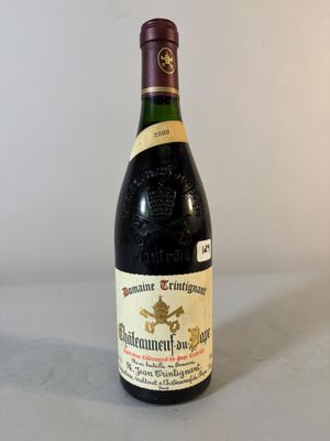 Des bouteilles de vin sont posées sur une table devant un mur blanc.