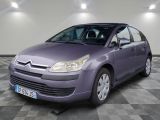 La voiture violette est garée sur un sol à damier dans le garage.
