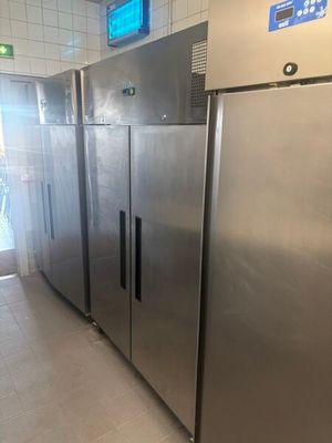 Des réfrigérateurs en acier inoxydable sont alignés les uns à côté des autres dans une cuisine professionnelle