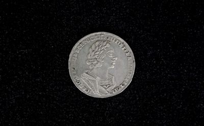 a close up of a silver coin on a black surface