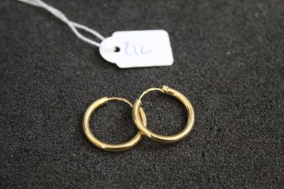 une paire de boucles d'oreilles en or sur une surface noire