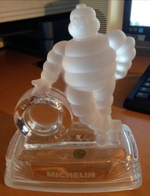 une figurine en verre représentant un homme, posée sur un bureau