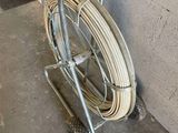 a cart with a hose attached to it next to a wall