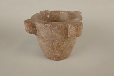 a stone vase that is sitting on a white surface