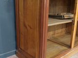 a wooden cabinet with a glass door and shelves