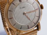 une montre-bracelet en or exposée sur un présentoir transparent