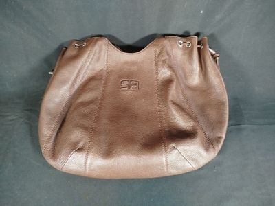 un gros plan d'un sac à main marron sur fond bleu
