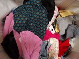 a pile of clothes sitting on a couch in a room