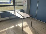 a desk with a laptop on it in a room with a large window